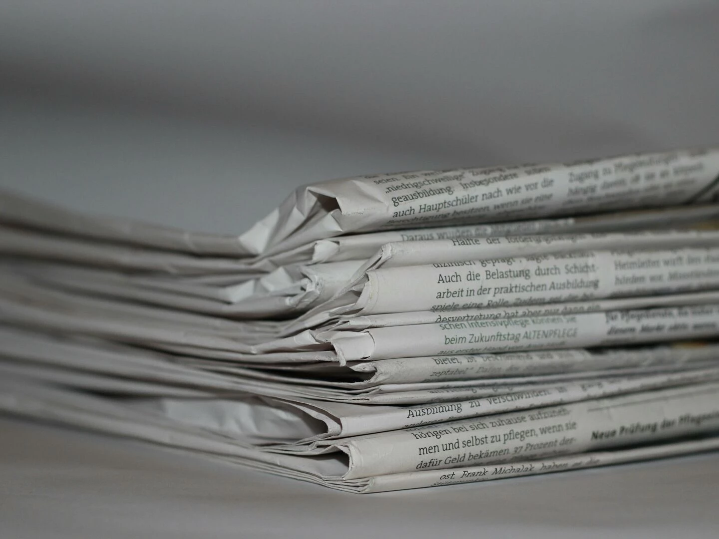 a closeup image of folded newspapers perfect for news or journalism themes