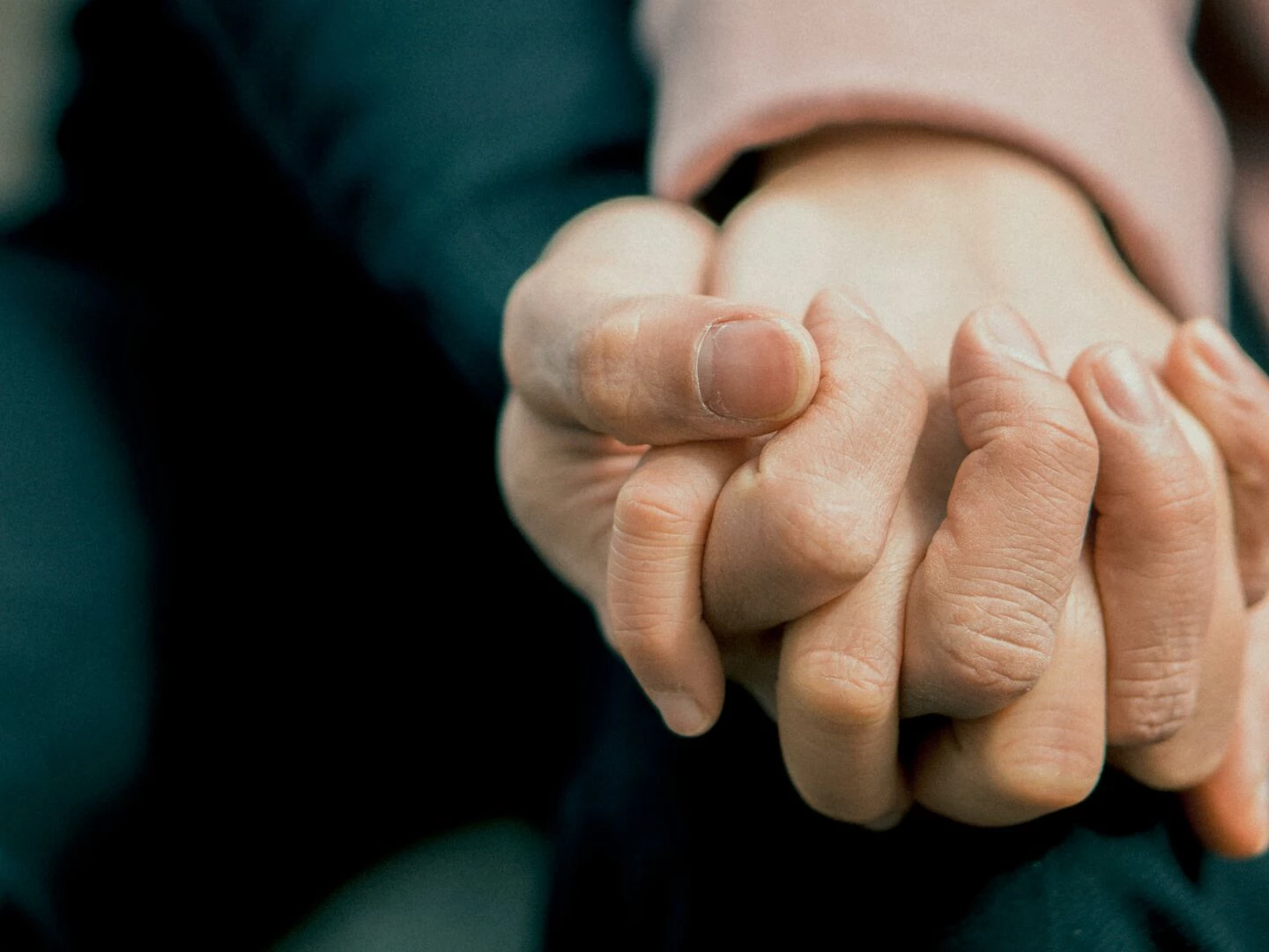 a closeup photo capturing two adult hands holding each other symbolizing love and support