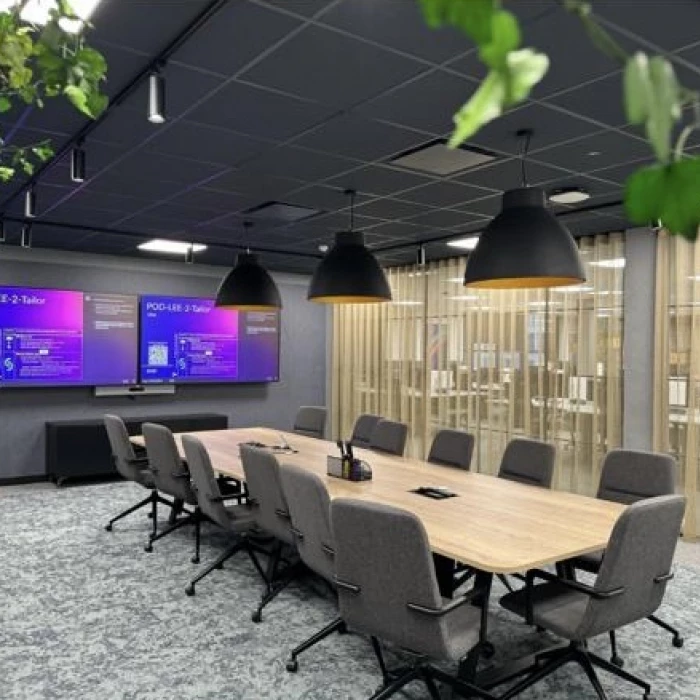 a company meeting room with computer screen displays on the wall
