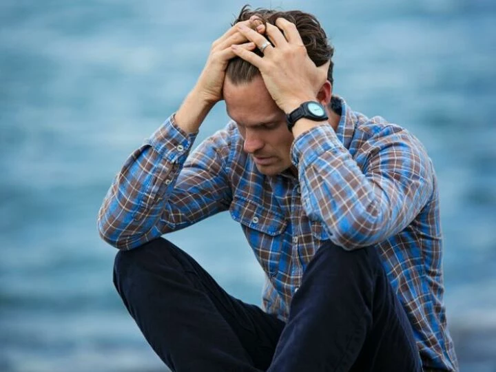 Man in Blue and Brown Plaid Dress Shirt Touching His Hair