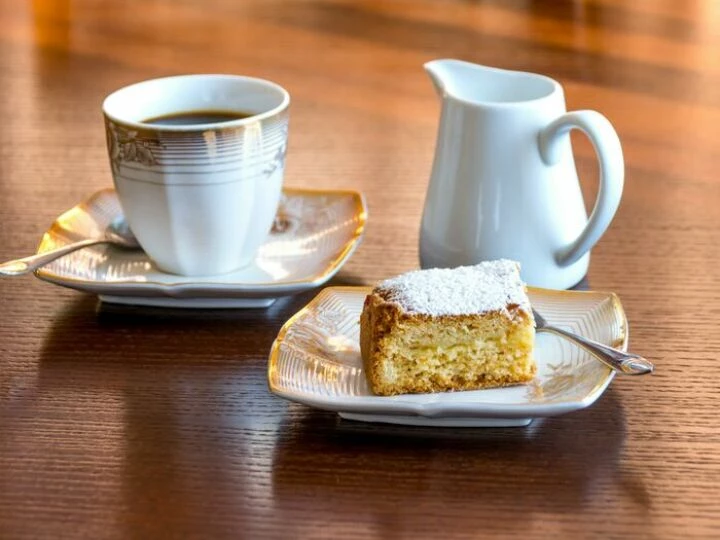 White Ceramic Mug Filled With Black Liquid Beside Baked Bread on Ceramic Saucer