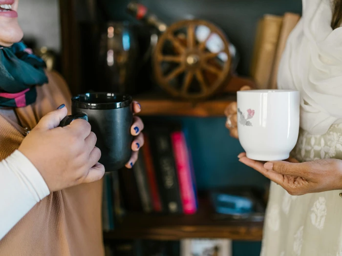 Close-up of Women Talking with Cups of Coffee in Their Hands 