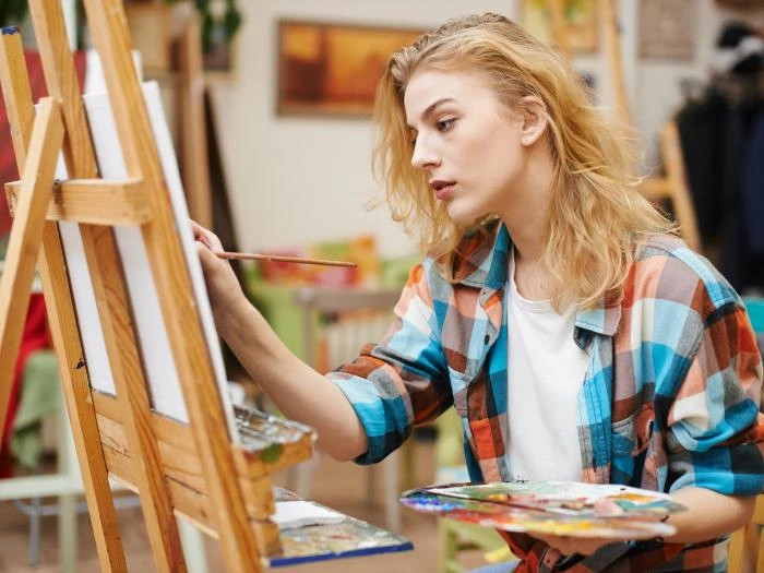 female artist at easel with paints