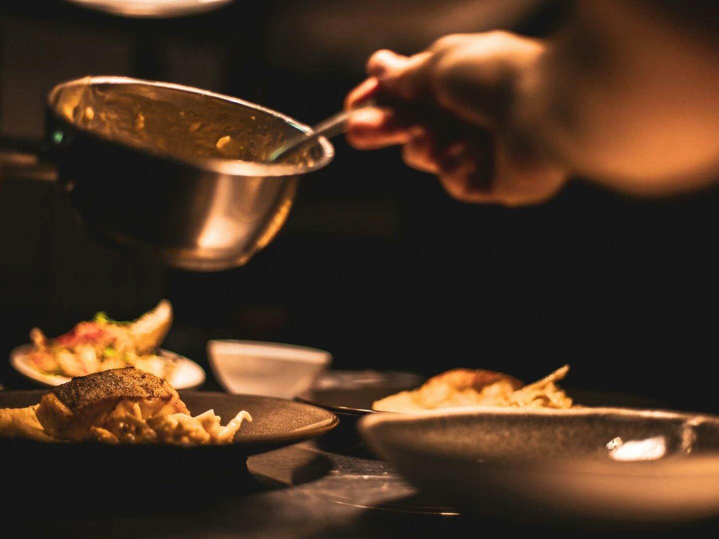 gourmet dish being plated by a chef in a dimly lit restaurant39s kitchen