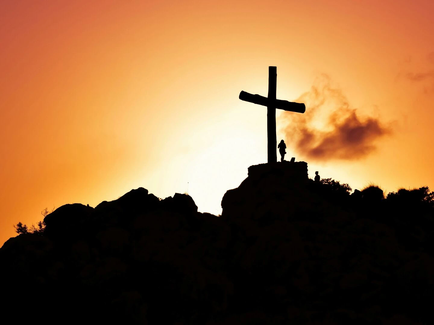 majestic silhouette of a cross on a hill during a vivid sunset symbolizing spirituality