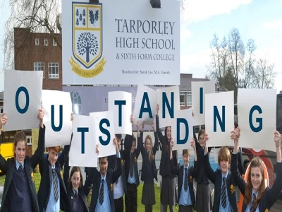 students holding outstanding letters smaller